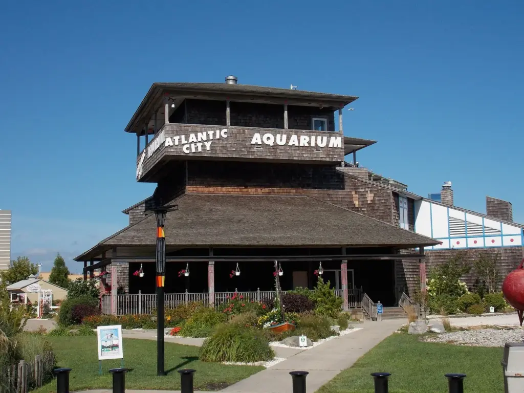 The wood-shingled Atlantic City Aquarium building with its rooftop lookout and a garden path in front