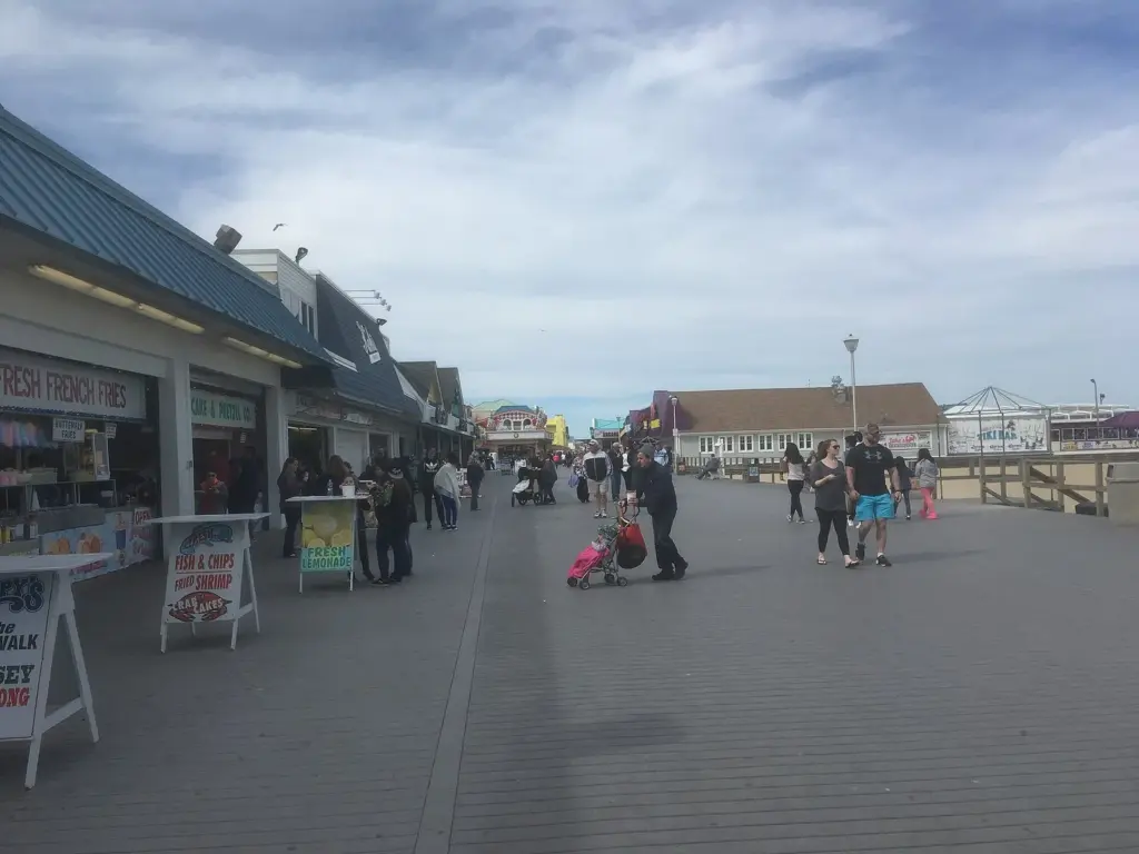 The wooden boardwalk at Point Pleasant Beach lined with food stands and shops, looking north toward Jenkinson's Aquarium