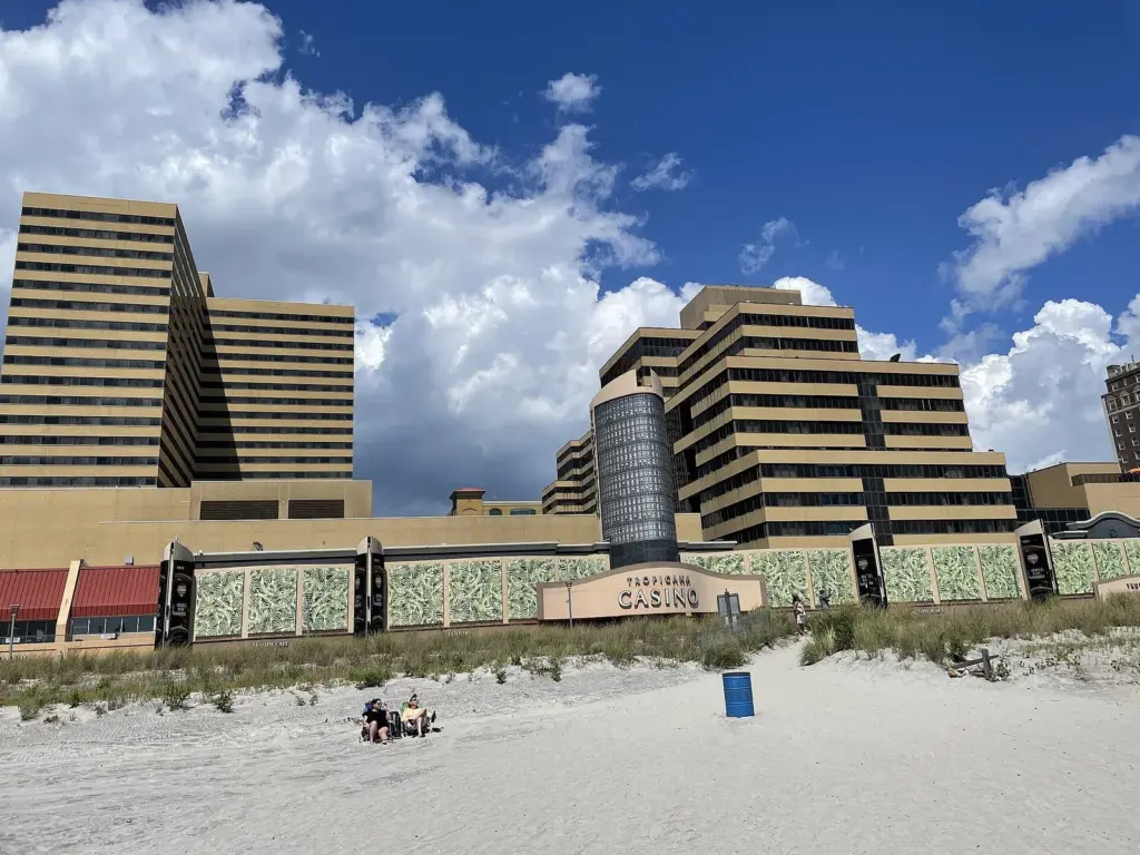 The Tropicana's stepped hotel towers rising behind the beach grass and sand, with a small sign reading Tropicana Casino