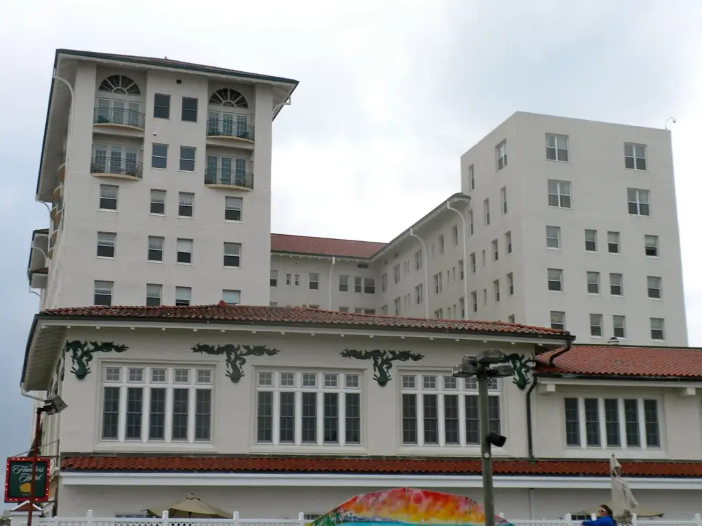 The Flanders Hotel's white stucco towers and red tile roofs, with green sea-creature ornaments over the tall windows of its lower wing